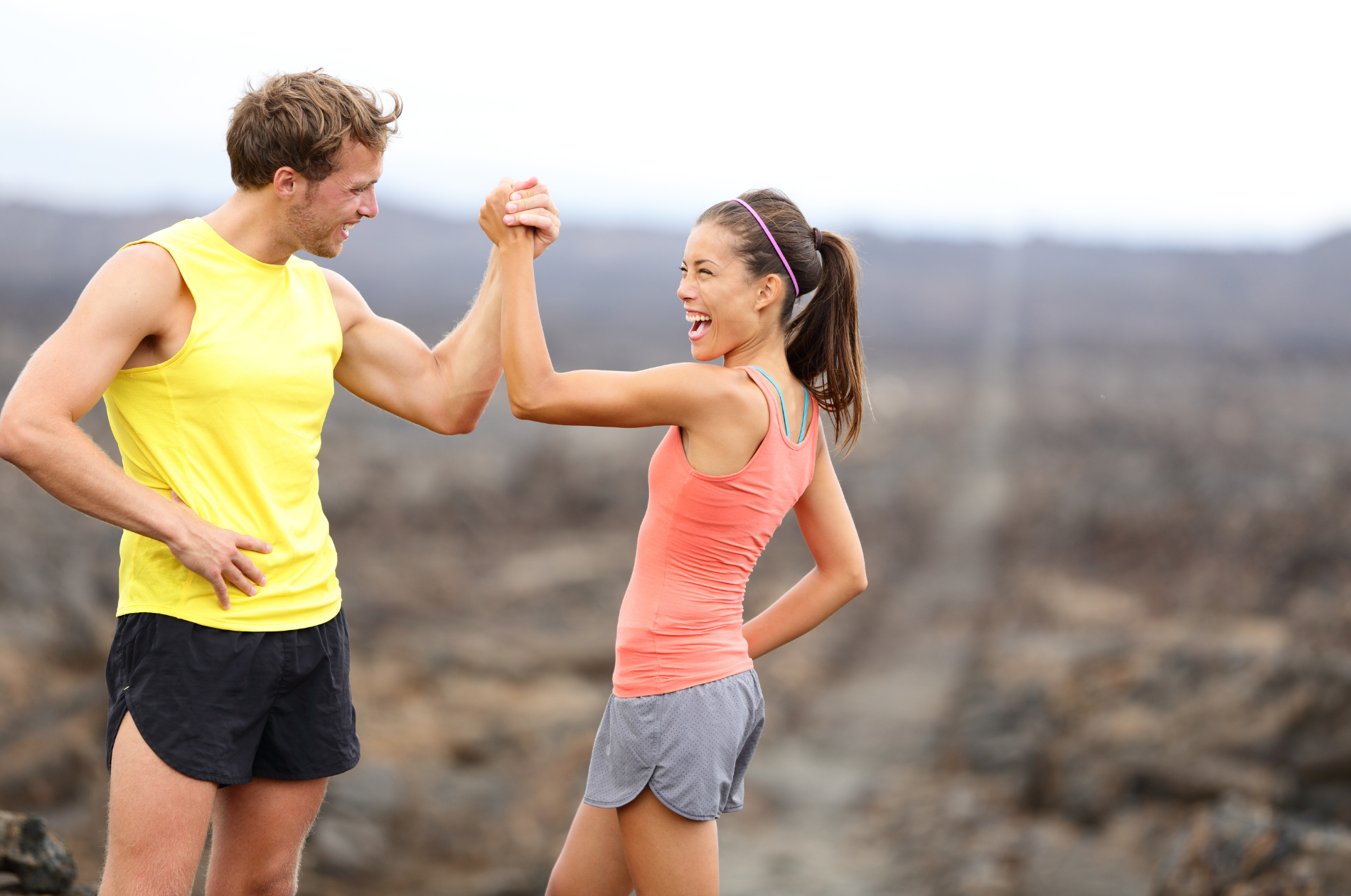 Man and woman with sculpted body join hands and smile